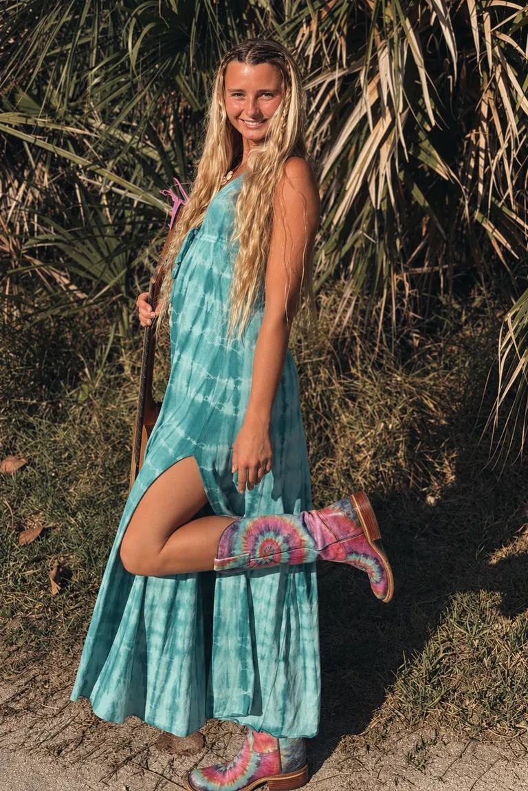 Lucy Spotts in a turquoise dress and boots at the coast.